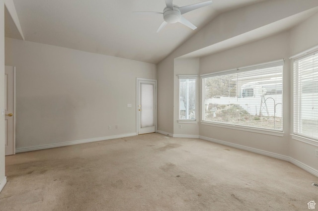 spare room featuring light carpet, a ceiling fan, baseboards, and vaulted ceiling