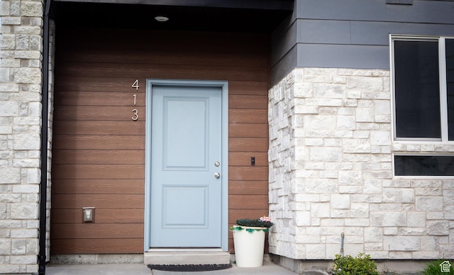 doorway to property featuring stone siding