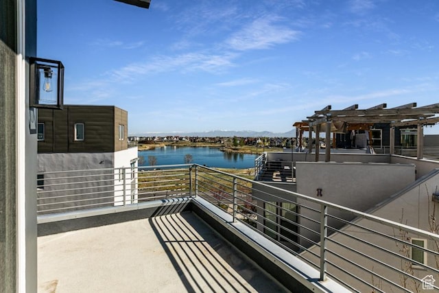 balcony featuring a pergola and a water view
