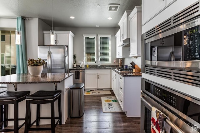 kitchen with plenty of natural light, a sink, a textured ceiling, and appliances with stainless steel finishes