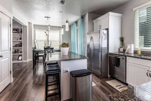 kitchen with stainless steel refrigerator with ice dispenser, dark wood-style flooring, dishwashing machine, and plenty of natural light