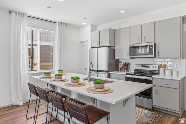 947 N Riverside Dr Unit 977, Saratoga Springs, UT 84045 - kitchen featuring stainless steel appliances, a sink, backsplash, gray cabinetry, and light countertops