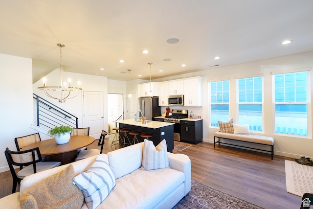 living area with a chandelier, wood finished floors, recessed lighting, and baseboards