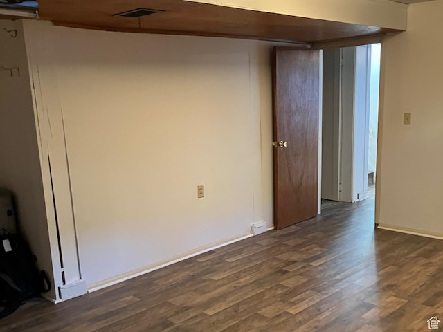 unfurnished room with visible vents, baseboards, and dark wood-style floors
