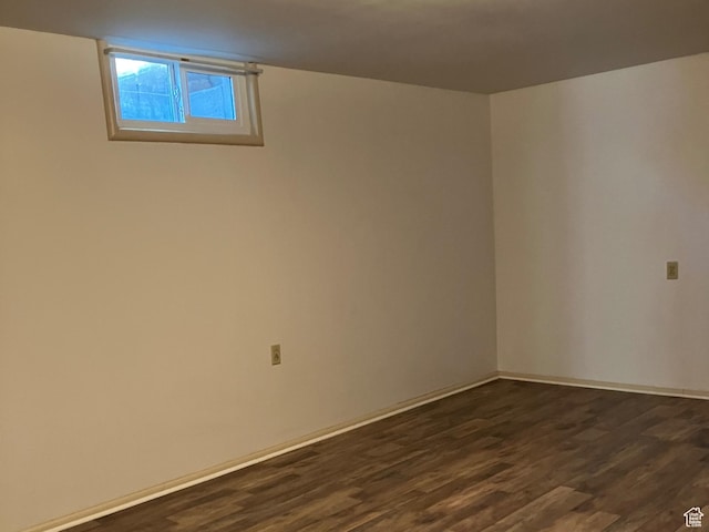 below grade area featuring dark wood finished floors and baseboards