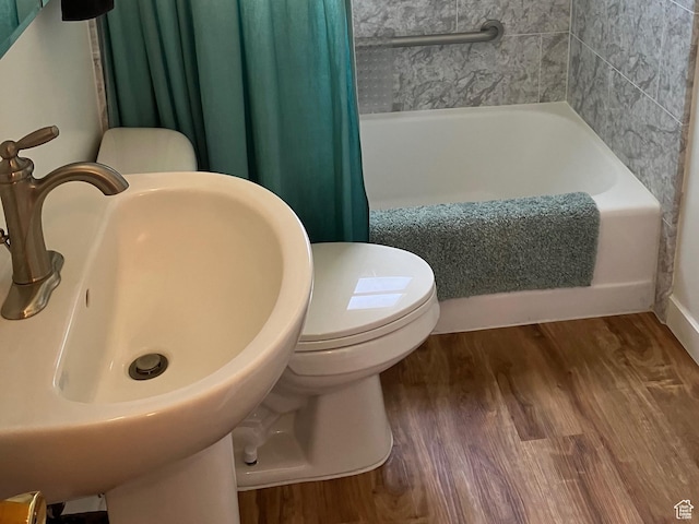 full bathroom featuring toilet, wood finished floors, and a sink