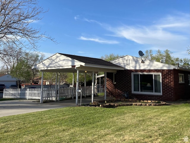 view of front facade featuring fence, driveway, brick siding, and a front yard