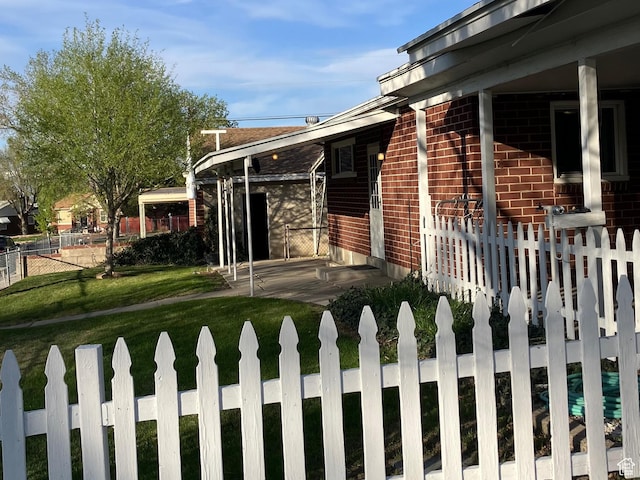 view of home's exterior with fence, a lawn, and brick siding