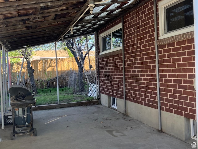 view of patio featuring fence and a grill