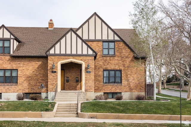 79 E Hillside Ave, Salt Lake City, UT 84103 - tudor house with brick siding, a front yard, and roof with shingles
