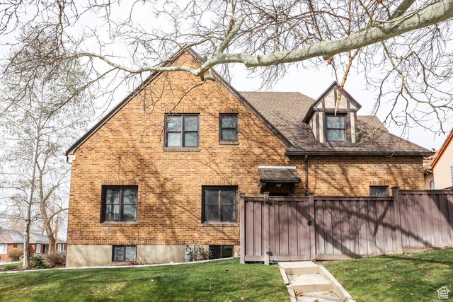 79 E Hillside Ave, Salt Lake City, UT 84103 - rear view of property with a gate, brick siding, fence, and a lawn