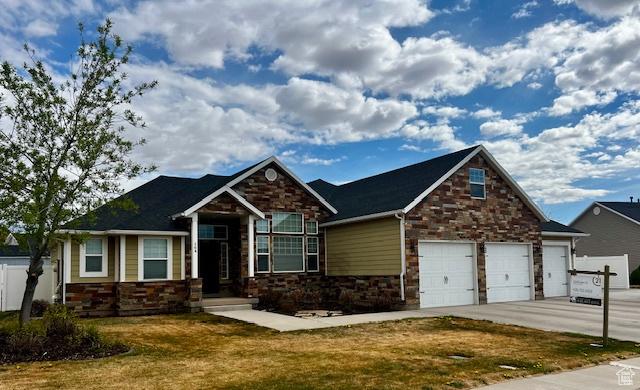 164 Park Ridge Dr, Roosevelt, UT 84066 - craftsman-style house featuring concrete driveway, a front lawn, stone siding, and a garage