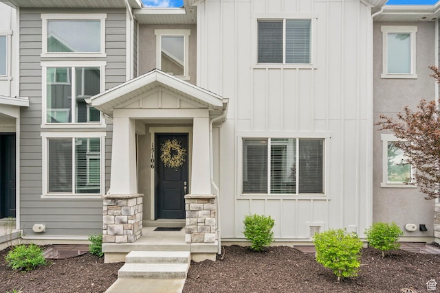 entrance to property with board and batten siding and stone siding