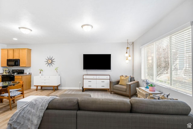 living area with baseboards and light wood-style flooring