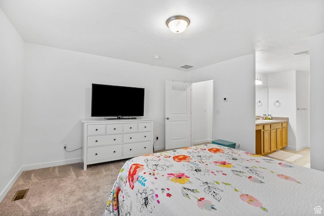 bedroom featuring visible vents, a sink, baseboards, and light colored carpet