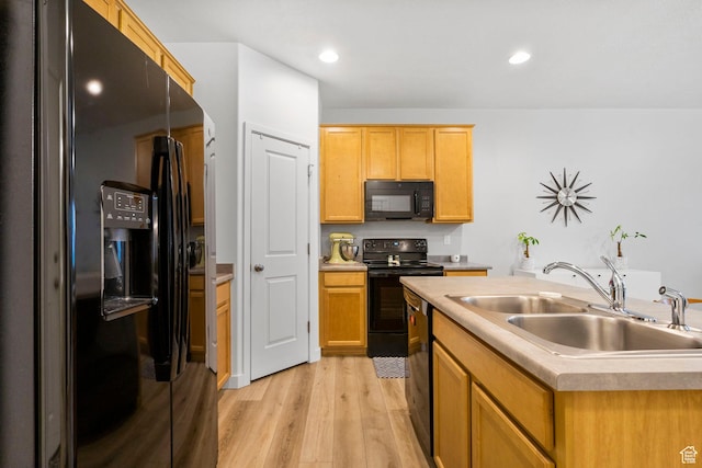 kitchen with recessed lighting, light countertops, a sink, light wood-style flooring, and black appliances