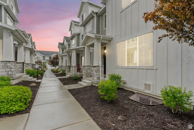 property exterior at dusk featuring a residential view and board and batten siding