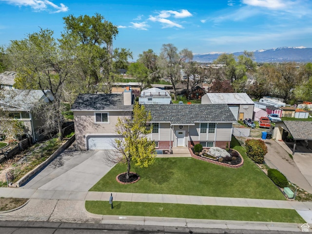 ranch-style house featuring concrete driveway, a front lawn, a mountain view, a garage, and a residential view
