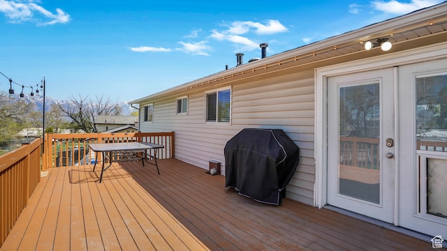 deck with grilling area, french doors, and outdoor dining space