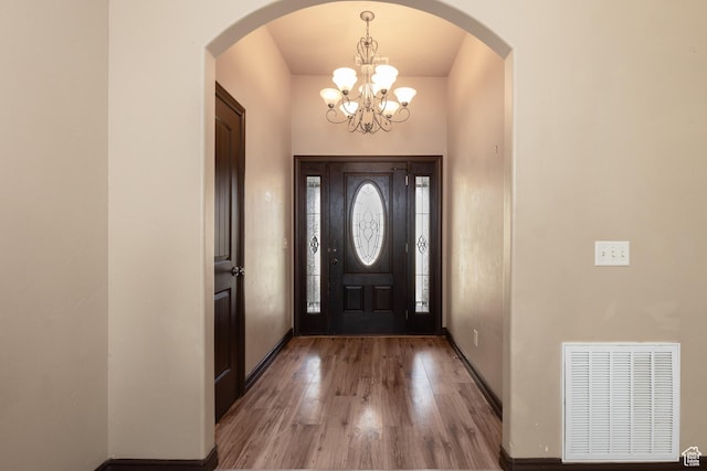 5095 N Ridgeview Cir, Enoch, UT 84721 - entrance foyer with arched walkways, baseboards, visible vents, an inviting chandelier, and wood finished floors