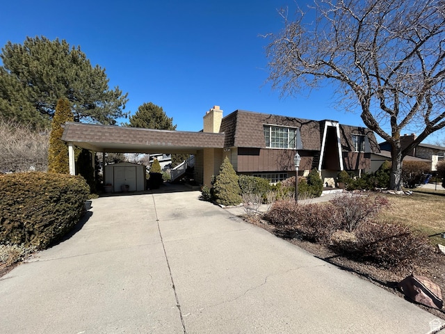 3748 W 5140 S, Taylorsville, UT 84129 - split level home with a chimney, driveway, an outbuilding, a storage unit, and roof with shingles