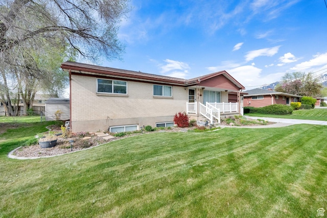 single story home with brick siding, a porch, and a front yard