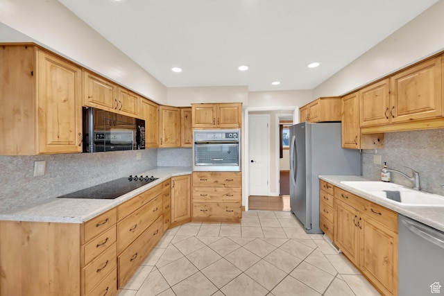 kitchen featuring a sink, black appliances, decorative backsplash, light tile patterned floors, and light countertops