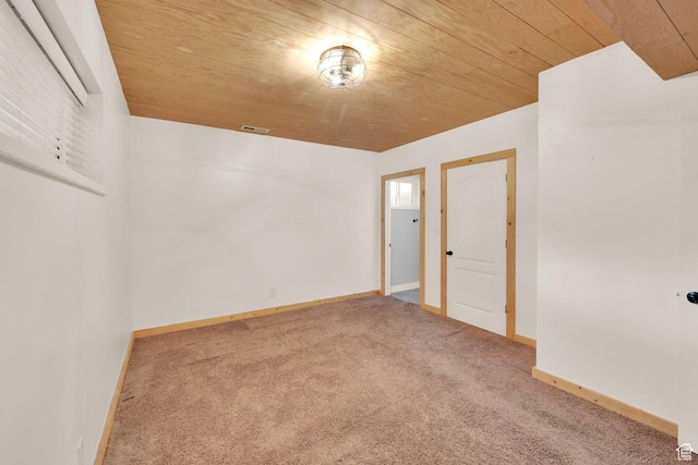 spare room with wood ceiling, baseboards, visible vents, and carpet