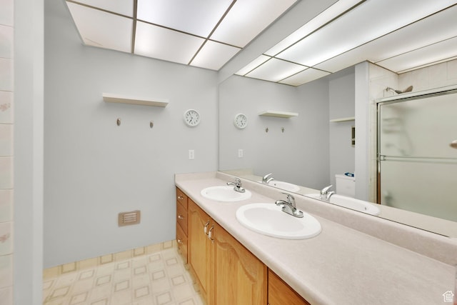 full bath with an enclosed shower, a sink, and tile patterned floors