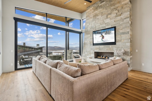 11431 N Ursa Cir Unit 56, Heber City, UT 84032 - living room with wood ceiling, baseboards, a stone fireplace, and light wood-type flooring