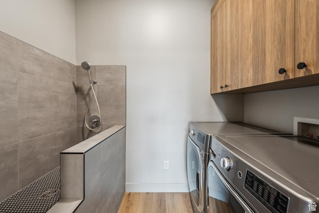 11431 N Ursa Cir Unit 56, Heber City, UT 84032 - clothes washing area with separate washer and dryer, light wood-style flooring, baseboards, and cabinet space