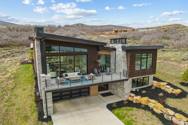 11431 N Ursa Cir Unit 56, Heber City, UT 84032 - rear view of property with an attached garage, stone siding, a balcony, and a mountain view