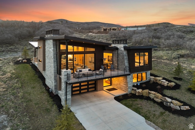 11431 N Ursa Cir Unit 56, Heber City, UT 84032 - back of property at dusk with a mountain view, driveway, a balcony, and a garage