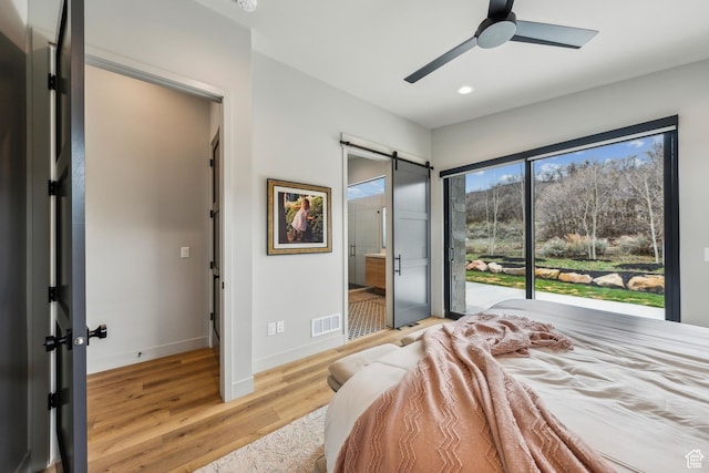 11431 N Ursa Cir Unit 56, Heber City, UT 84032 - bedroom featuring a barn door, recessed lighting, visible vents, light wood-type flooring, and baseboards