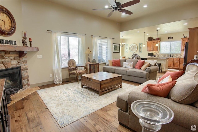 2630 E Riley Dr N, Eagle Mountain, UT 84005 - living area with a ceiling fan, light wood-style floors, a fireplace, baseboards, and recessed lighting