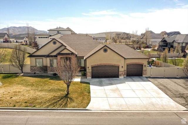 view of front of home with driveway, fence, an attached garage, a front yard, and stucco siding