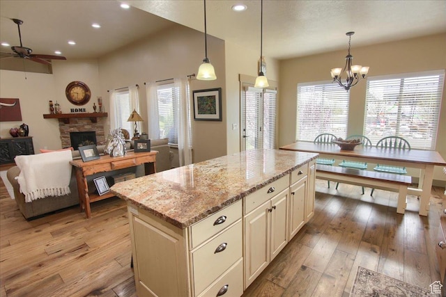 2630 E Riley Dr N, Eagle Mountain, UT 84005 - kitchen with light wood-type flooring, plenty of natural light, and ceiling fan with notable chandelier