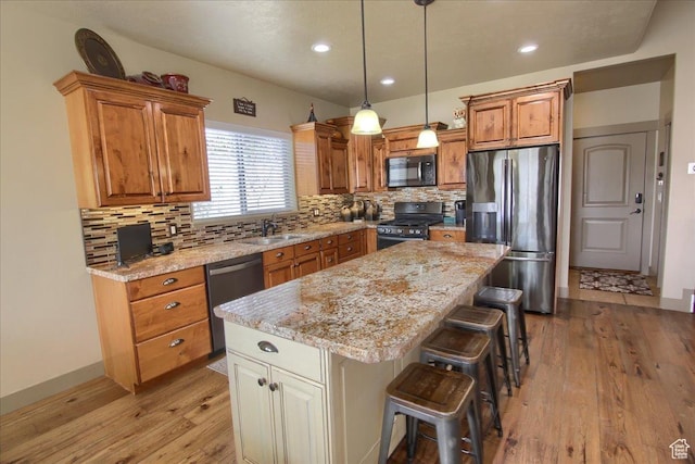 2630 E Riley Dr N, Eagle Mountain, UT 84005 - kitchen featuring light wood-style flooring, a breakfast bar area, decorative backsplash, and black appliances