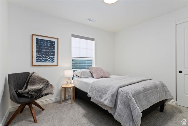 bedroom with baseboards, visible vents, and light colored carpet