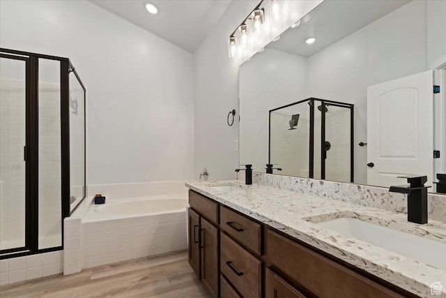 full bathroom featuring a garden tub, wood finished floors, a sink, and a shower stall