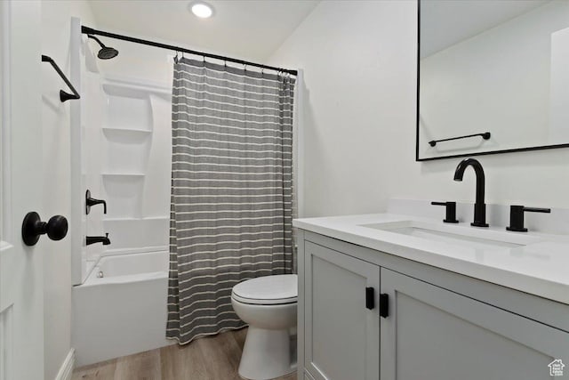 full bath featuring shower / bath combo, wood finished floors, toilet, and vanity