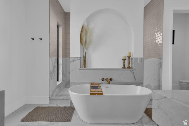 565 W Autumn Blaze, Woodland Hills, UT 84653 - bathroom with marble finish floor, a wainscoted wall, toilet, tile walls, and a freestanding tub