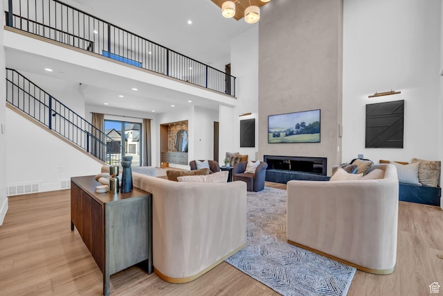 565 W Autumn Blaze, Woodland Hills, UT 84653 - living room featuring a high ceiling, a glass covered fireplace, wood finished floors, and visible vents