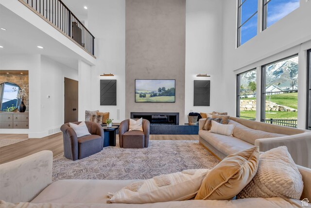565 W Autumn Blaze, Woodland Hills, UT 84653 - living room with a high ceiling, a glass covered fireplace, wood finished floors, and visible vents
