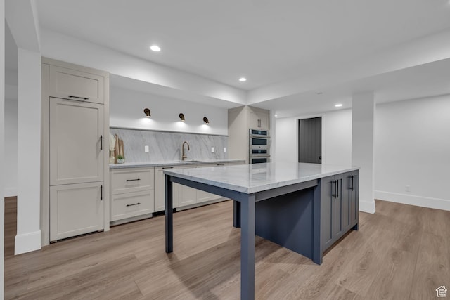 565 W Autumn Blaze, Woodland Hills, UT 84653 - kitchen featuring double oven, a sink, light wood-type flooring, baseboards, and tasteful backsplash