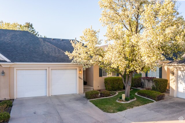 11855 S Cottage Side Way E, Draper, UT 84020 - view of front of home with an attached garage, a shingled roof, stucco siding, and concrete driveway