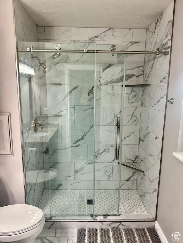 bathroom with marble finish floor, toilet, and a marble finish shower