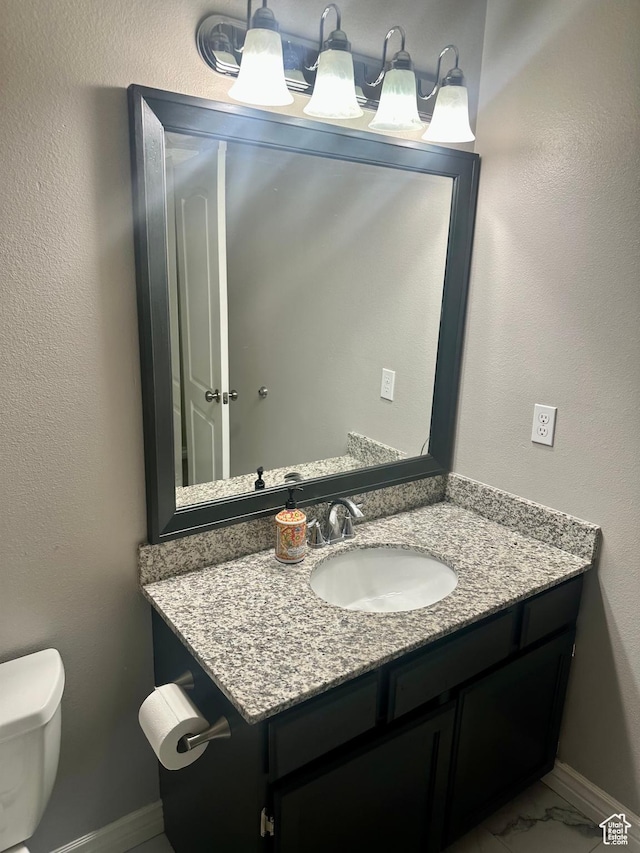 bathroom featuring marble finish floor, vanity, toilet, and baseboards