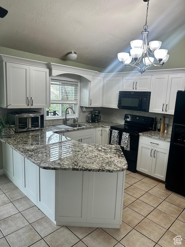 kitchen featuring black appliances, white cabinetry, a sink, and light tile patterned floors