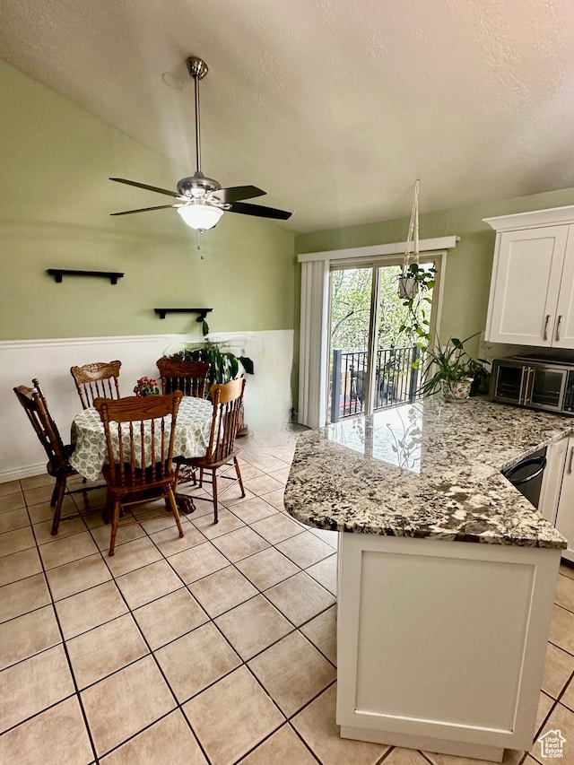 interior space featuring white cabinets, light stone countertops, a peninsula, a textured ceiling, and ceiling fan